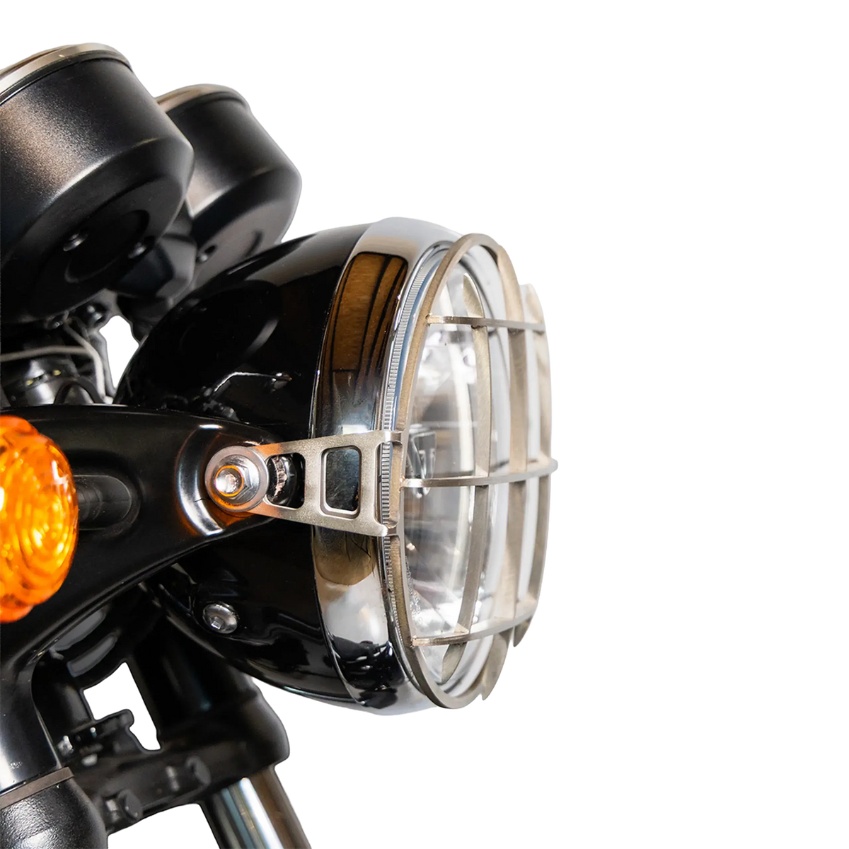 Grille de phare brossee montee sur Triumph Bonneville T120, vue rapprochee de trois quarts du phare - FCR Accessoires