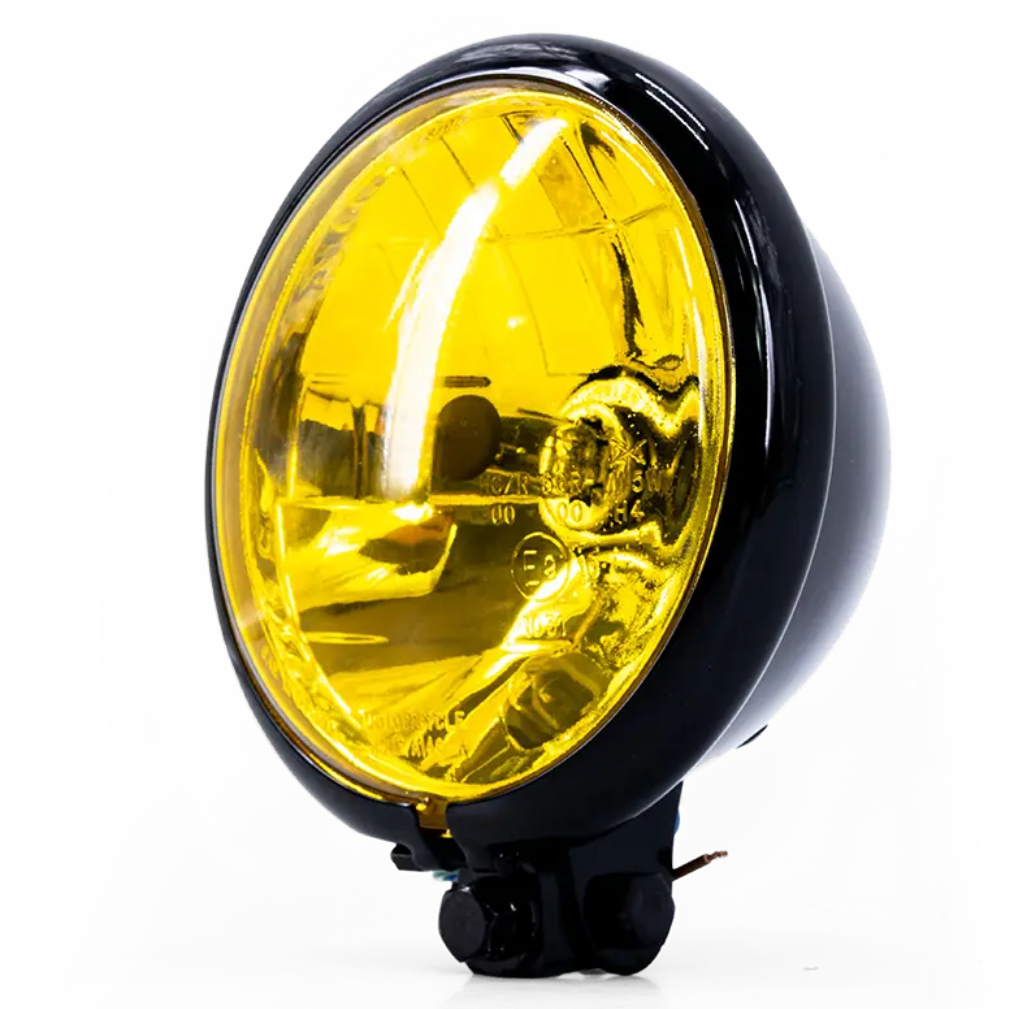 Phare rond avant Triumph Vintage Bates, optique jaune, cuvelage noir, vue trois-quarts avant droite.